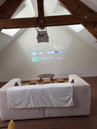 a bed in a room with a screen on the wall at Le Studio in Milly-sur-Thérain