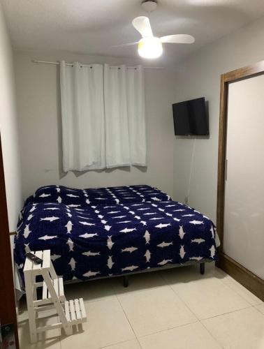 a bedroom with a bed with a blue cover with stars at Praia da Costa próx da Praia in Vila Velha