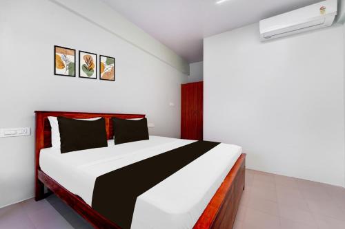 a bedroom with a black and white bed in it at Collection O Karumathampatti in Coimbatore