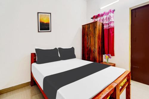 a bedroom with a bed and a red window at Super Hotel O Okkilipalayam in Coimbatore