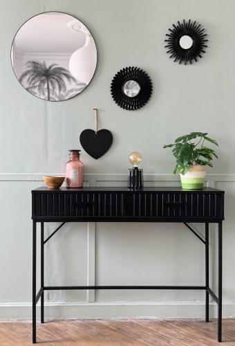 a black console table in a living room with a mirror at La maison du Maréchal in Parthenay