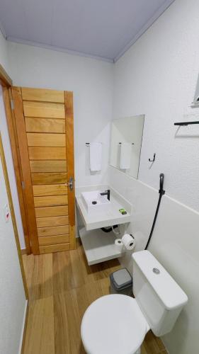 a bathroom with a white toilet and a sink at Hotel Luxx Sorriso in Sorriso