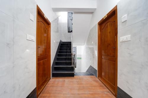 a hallway with two wooden doors and a staircase at Townhouse Coimbatore International Airport Formerly MK Elegance Inn in Coimbatore