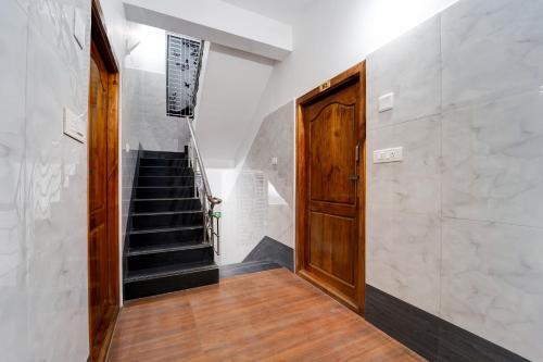 a hallway with a staircase and a wooden door at Townhouse Coimbatore International Airport Formerly MK Elegance Inn in Coimbatore