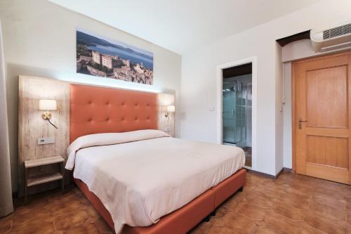 a bedroom with a large bed with an orange headboard at Albergo Della Posta in Bracciano