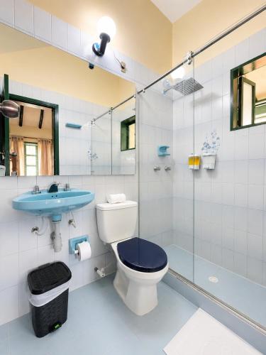 a bathroom with a toilet and a sink and a shower at Hotel Altair in Villa de Leyva
