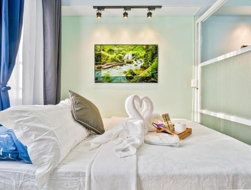 a bedroom with a bed with white sheets and bunny pillows at Lumiere Prime Studio - Mactan Pool Escape in Pajak