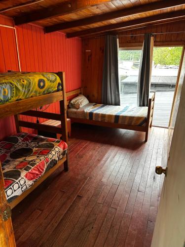 a room with two bunk beds and a window at Hostal Palguin 261 in Pucón