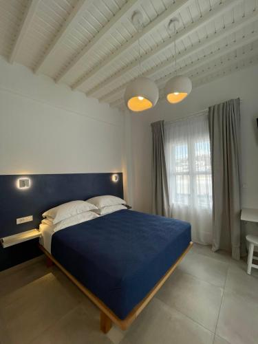 a bedroom with a blue bed and a window at Gemelos Cozy Stay in Megali Ammos