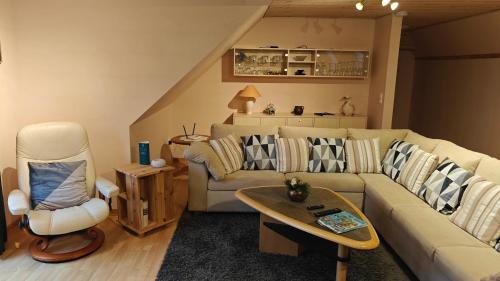 a living room with a couch and a chair at Fewo Skjærnsøde in Fjerritslev