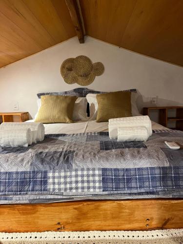 a large bed with a blue and white comforter at Casa bambu atins in Atins