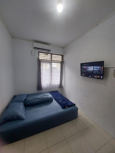 a bedroom with a blue bed in a room at Omah Diaz Homestay Malioboro in Jetis