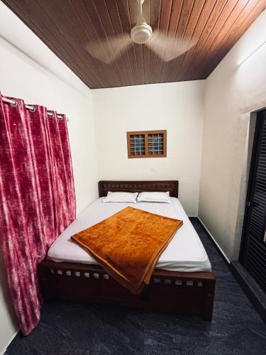 a bed with a blanket on it in a room at Palm paradise in Kadavoor