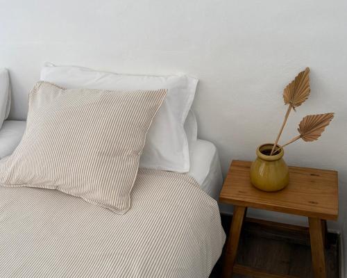 a bed with two pillows and a vase on a table at Casa Joanna Lanzarote in Nazaret