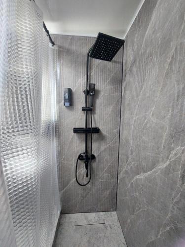 a bathroom with a shower with a glass door at Премиум квартира в современном стиле in Līsakovsk