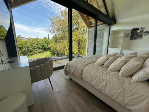 a bedroom with a large bed and a large window at Maison Unifamiliale in Theux