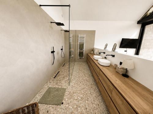 a bathroom with two sinks and a glass shower at Maison Unifamiliale in Theux