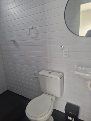 a bathroom with a white toilet and a mirror at Repouso Box in Cabo de Santo Agostinho