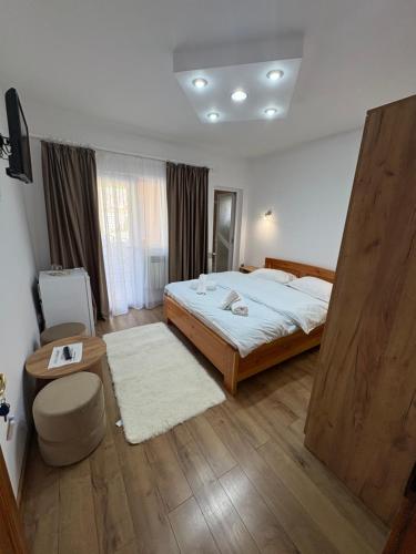 a bedroom with a large bed and a table at Casa Visescu in Băile Herculane