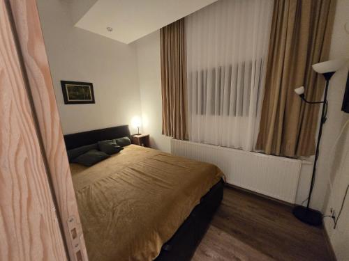 a small bedroom with a bed and a window at Ski & SunDeck in Bjelašnica