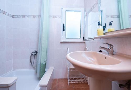 a white bathroom with a sink and a shower at Apartments Vrtina in Igrane