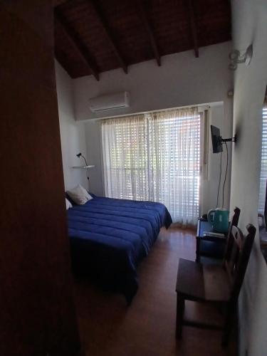 a bedroom with a blue bed and a large window at SL 1908 in Olivos