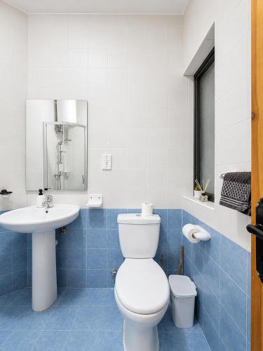 a bathroom with a white toilet and a sink at Central Msida Modern Holiday Apartment in Tal-Ħriereb