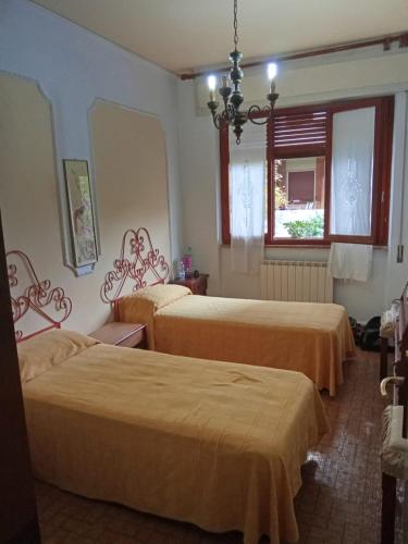 a room with three beds and a chandelier at Caterina in Marina di Massa