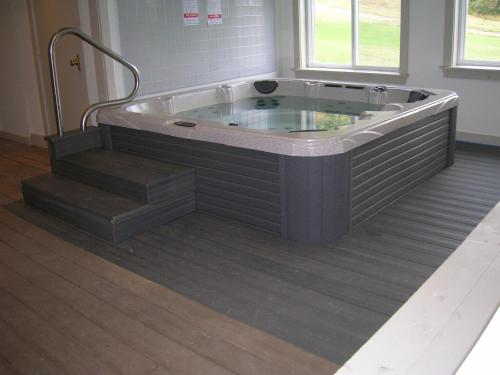 a jacuzzi tub with stairs in a room at Mittersill Alpine Resort in Franconia