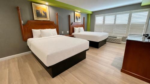 a hotel room with two beds and a desk at The SeaScape Inn in San Francisco