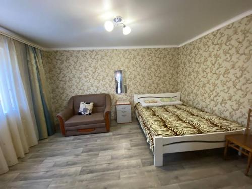 a bedroom with a bed and a chair in it at Bugazik in Karolino-Buhaz