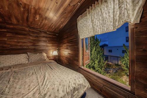a bedroom with a bed and a large window at Bear house Dalat in Da Thien
