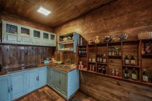 a kitchen with blue cabinets and wooden walls at Bear house Dalat in Da Thien