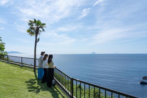 a group of people standing next to the ocean at 河津Blue Ocean in Kawazu