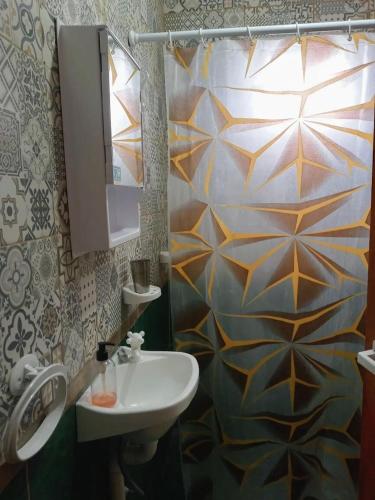 a bathroom with a sink and a shower curtain at Los 3 Gurises in Gualeguay