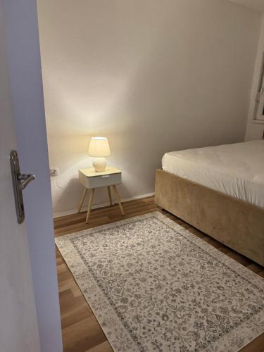 a bedroom with a bed and a table with a lamp at Apartman Ana in Neum