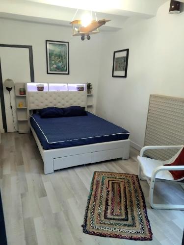 a bedroom with a bed and two chairs and a rug at Les Pipistrelles in Bagard
