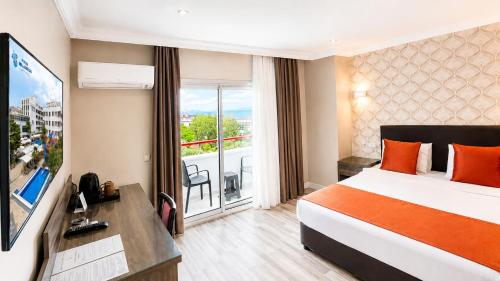 a hotel room with a bed and a balcony at Hotel Billurcu in Ayvalık