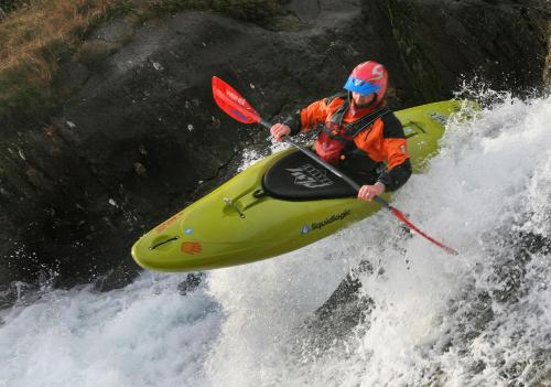 a man is in a kayak on a waterfall at Wild Camping Teepee in Capel Curig