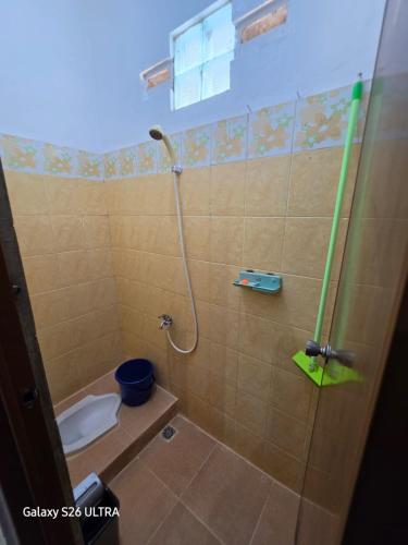 a bathroom with a shower with a toilet and a sink at Omah Diaz Homestay Malioboro in Jetis