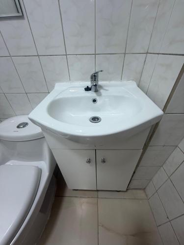 a white bathroom with a sink and a toilet at Hotel boutique Blanca Gazza in Arica