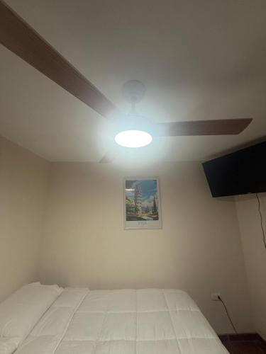 a bedroom with a white bed and a ceiling fan at Hotel boutique Blanca Gazza in Arica