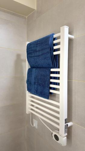a towel rack in a bathroom with blue towels at Studio Moderne - Proche 15mn Orly et 25mn Paris in Juvisy-sur-Orge