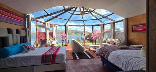 a bedroom with two beds in a glass house at Titicaca Aruntawi Lodge Peru in Puno