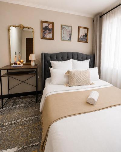 a bedroom with a large bed and a mirror at Garden View Suite in Gqeberha