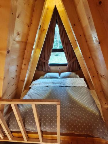 a bed in a room with a window at Zvezdana šuma in Žabljak