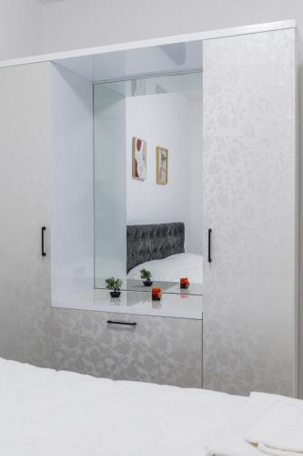 a white room with a bed and a mirror at Anchor Apartments in Shëngjin