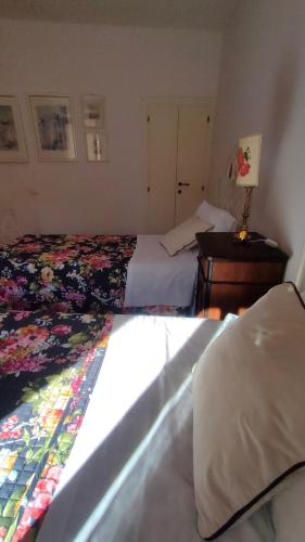 a bedroom with two beds and a desk with a lamp at Ciliano 16 in Montepulciano