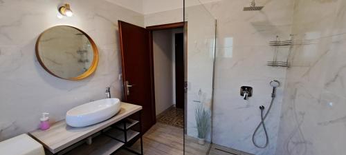 a bathroom with a sink and a glass shower at Apartments Desiree & Daniel in Dramalj