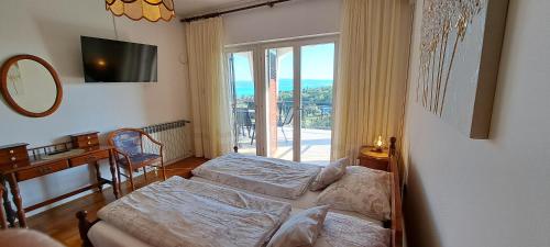a bedroom with two beds and a window at Apartments Desiree & Daniel in Dramalj